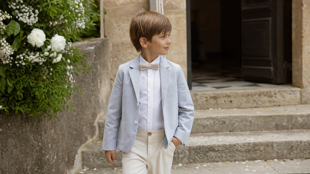 Garçon en tenue de cérémonie avec accessoires adaptés pour un mariage. Billede