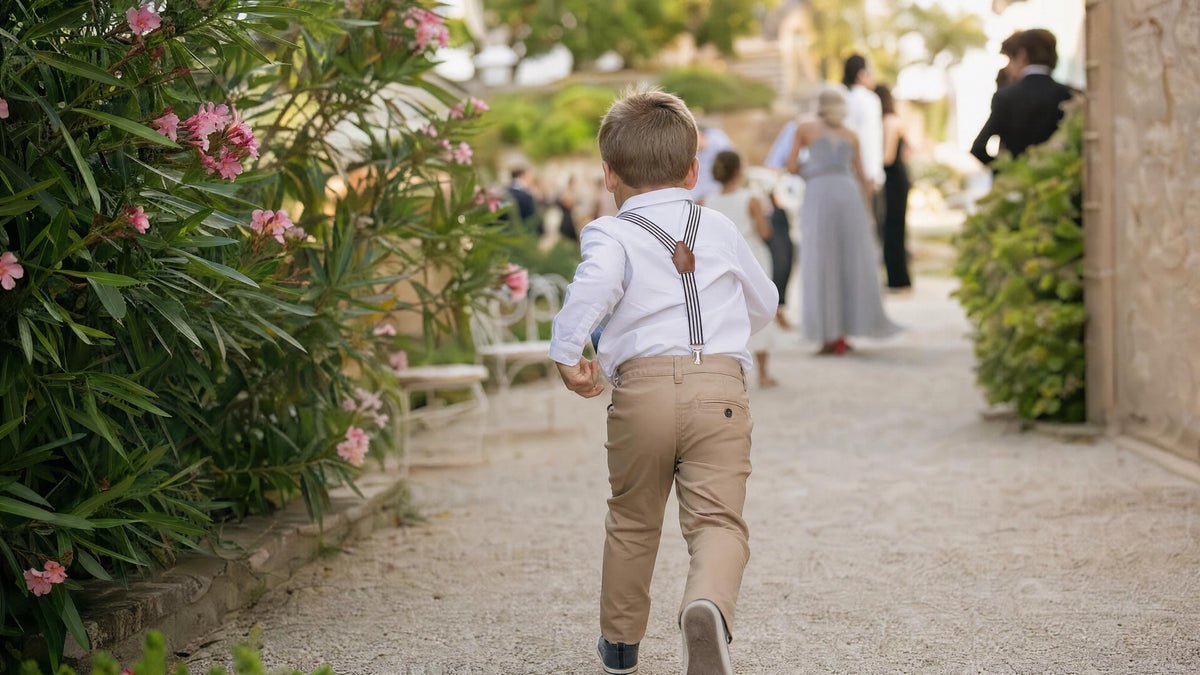 Enfant portant des bretelles pour une cérémonie, tenue élégante et naturelle. Billede